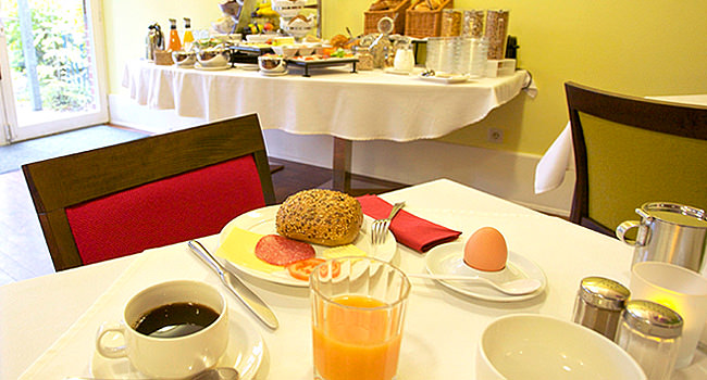 Frühstückstisch mit Körnerbrötchen, Ei und Orangensaft
